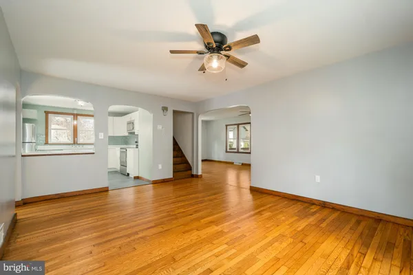 a view of an empty room with window and wooden floor