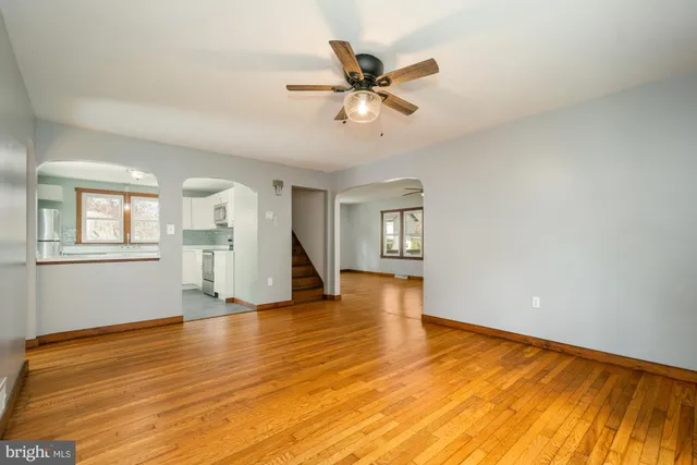a view of an empty room with window and wooden floor