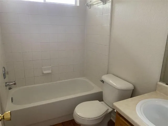 a white toilet and tub sitting next to a bathroom sink