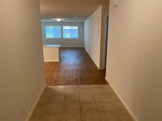 a view of a hallway with wooden floor and a window