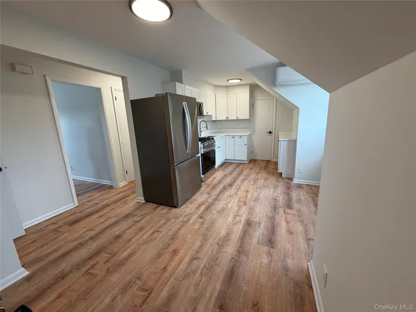 a view of kitchen with refrigerator stove and wooden floor