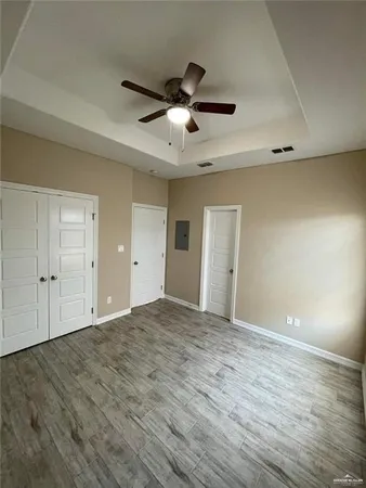 a view of an empty room and chandelier fan