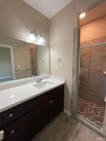a bathroom with a double vanity sink mirror and shower