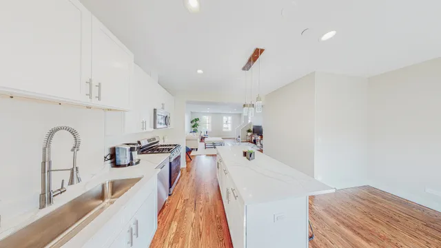 a large kitchen with stainless steel appliances granite countertop a stove a sink and a refrigerator