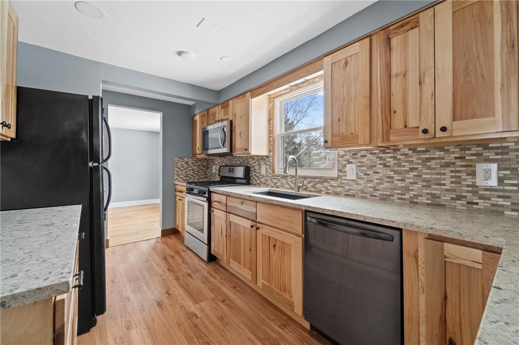 1015 McNeilly Road Pittsburgh, PA 15226 - Photo 7 of 19 a kitchen with stainless steel appliances granite countertop a refrigerator a sink dishwasher a stove and white countertops with wooden floor