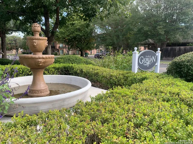a view of a fountain in the garden of a house