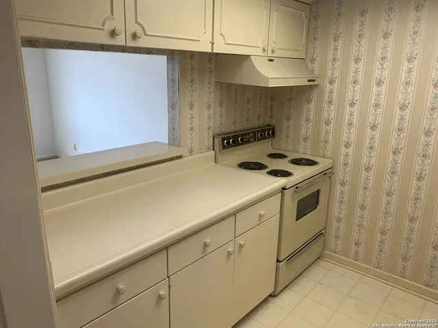 a front view of a house with a yard and potted plants