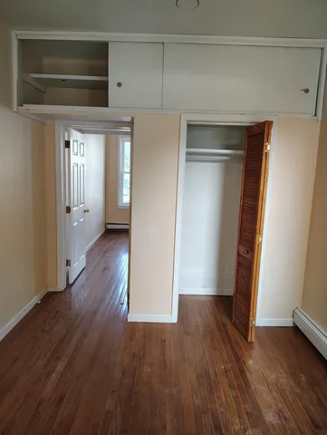 an empty room with wooden floor and a window