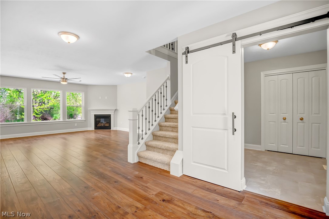 12412 Snow Road Burton, OH 44021 - Photo 19 of 45 Staircase featuring ceiling fan, hardwood / wood-style flooring, and a barn door