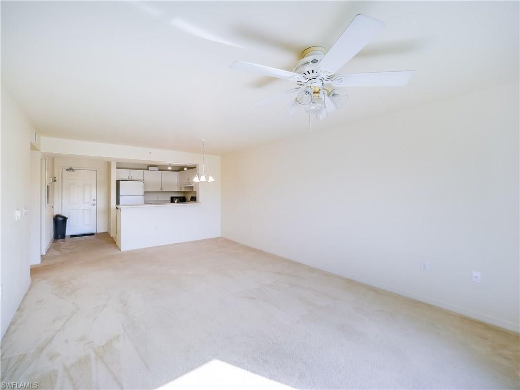 8224 Key Royal Circle, Unit 223 Naples, FL 34119 - Photo 5 of 14 a view of a room with chandelier fan and fire place