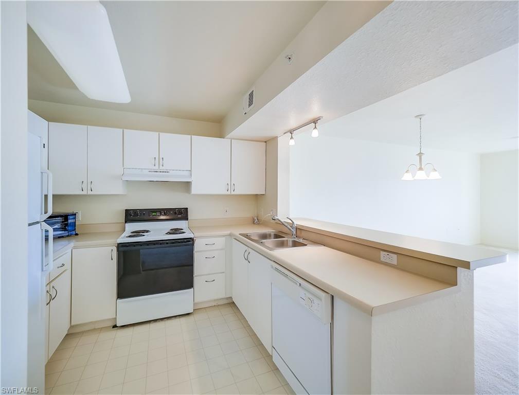 8224 Key Royal Circle, Unit 223 Naples, FL 34119 - Photo 7 of 14 a kitchen with stainless steel appliances granite countertop a sink and a stove
