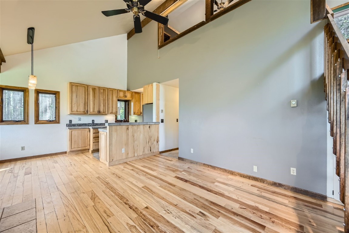 204 Blue Ridge Road Breckenridge, CO 80424 - Photo 22 of 40 Kitchen featuring light hardwood / wood-style floors, hanging light fixtures, ceiling fan, and a towering ceiling