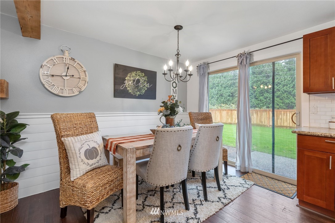 3118 167th Street Southeast Bothell, WA 98012 - Photo 12 of 38 a dining room with furniture a chandelier and wooden floor