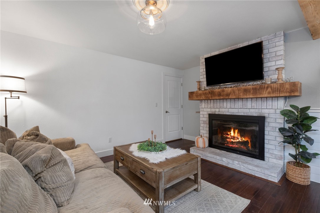 3118 167th Street Southeast Bothell, WA 98012 - Photo 15 of 38 a living room with furniture a flat screen tv and a fireplace