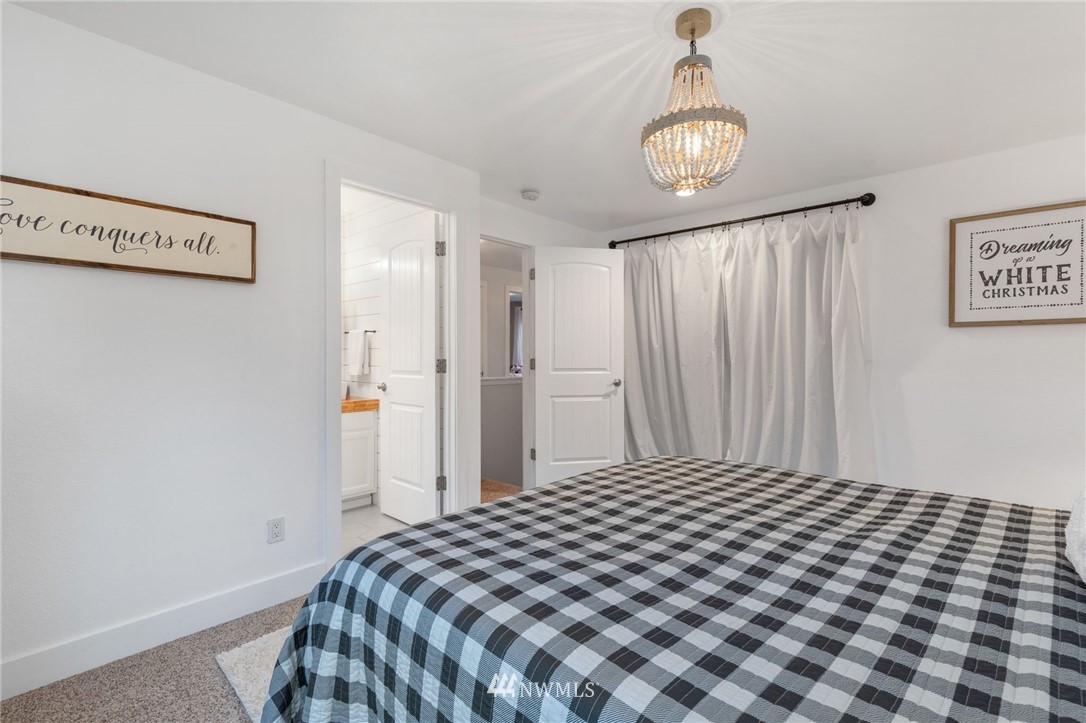 3118 167th Street Southeast Bothell, WA 98012 - Photo 23 of 38 a bedroom with a bed and a chandelier