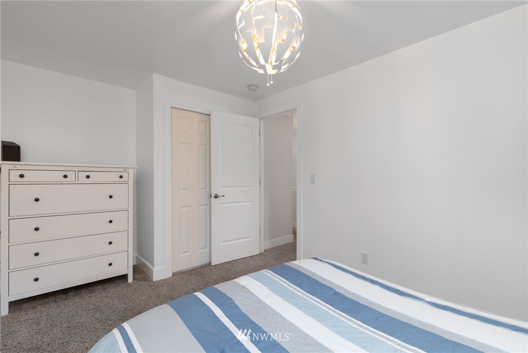 3118 167th Street Southeast Bothell, WA 98012 - Photo 28 of 38 a bedroom with a bed and a chandelier
