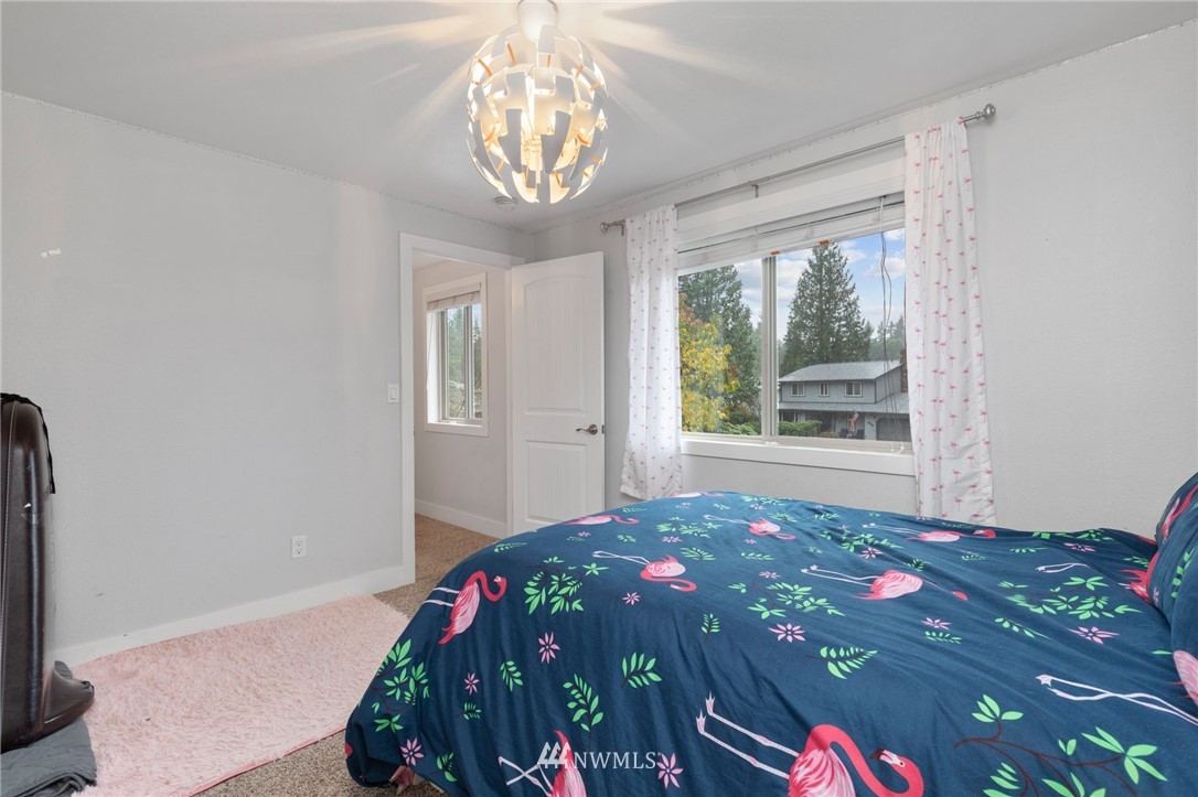 3118 167th Street Southeast Bothell, WA 98012 - Photo 31 of 38 a bedroom with a bed and a chandelier