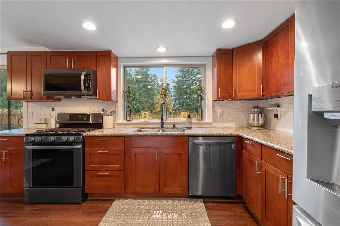 3118 167th Street Southeast Bothell, WA 98012 - Photo 8 of 38 a kitchen with a sink stove and microwave