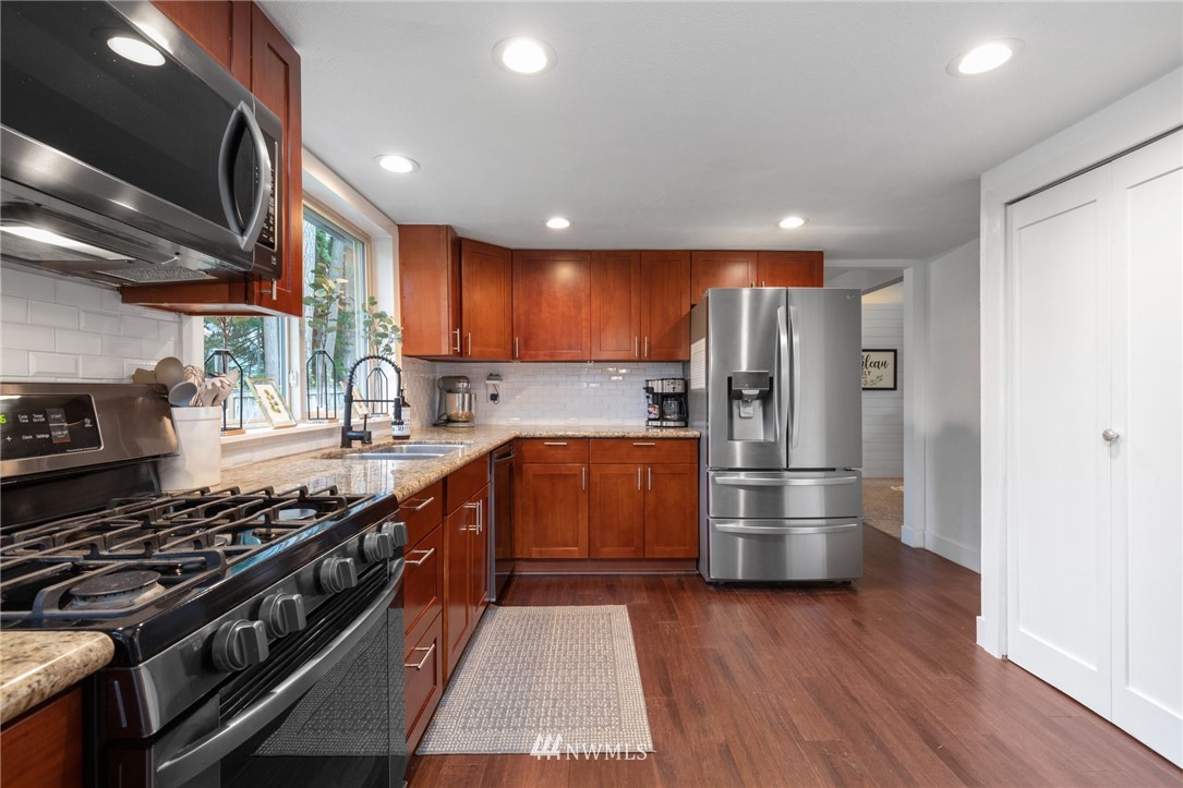 3118 167th Street Southeast Bothell, WA 98012 - Photo 10 of 38 a kitchen with stainless steel appliances granite countertop a stove a refrigerator and a sink