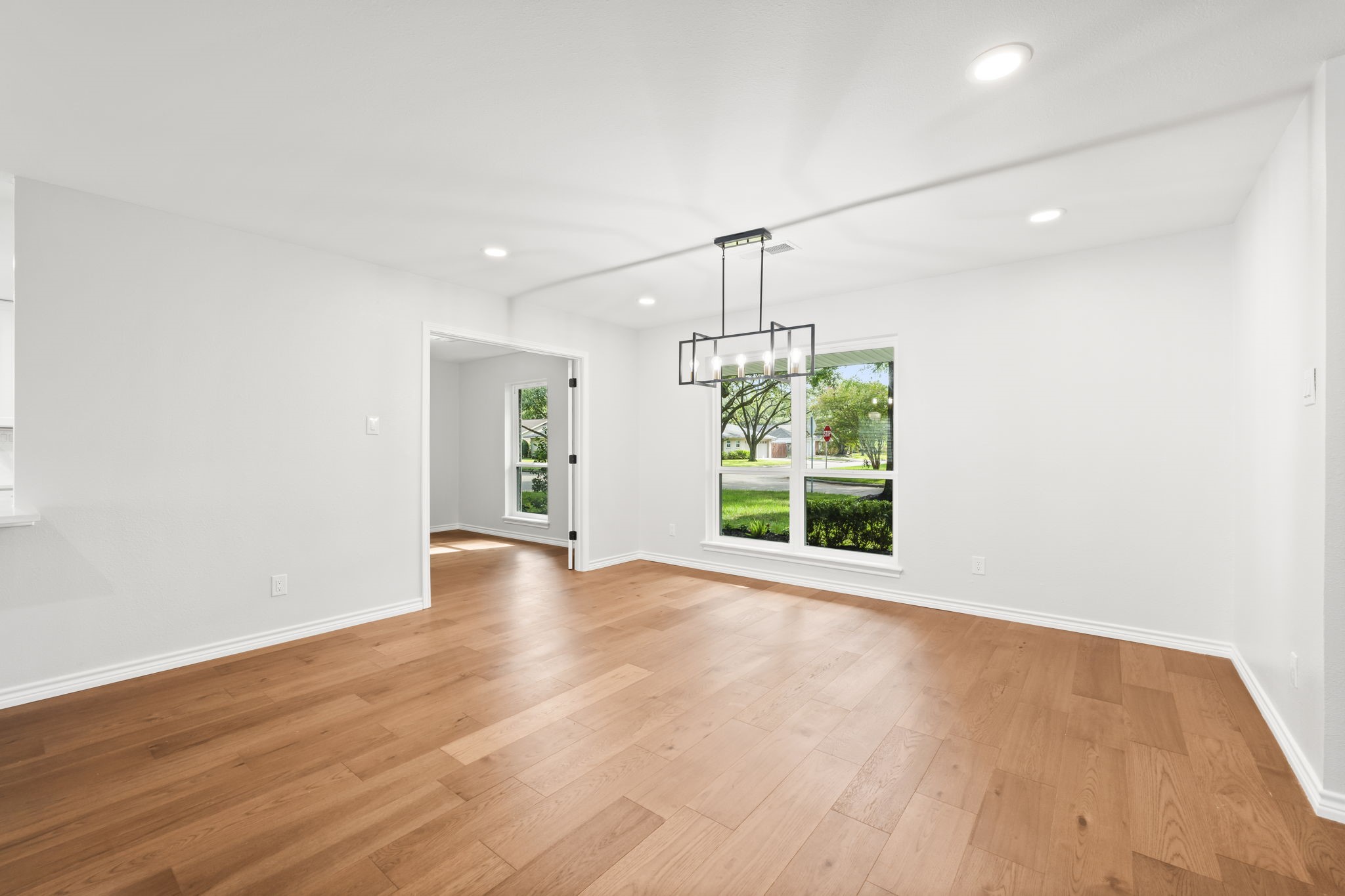 2535 Southwick Street Houston, TX 77080 - Photo 12 of 26 a view of an empty room with wooden floor kitchen view and a window