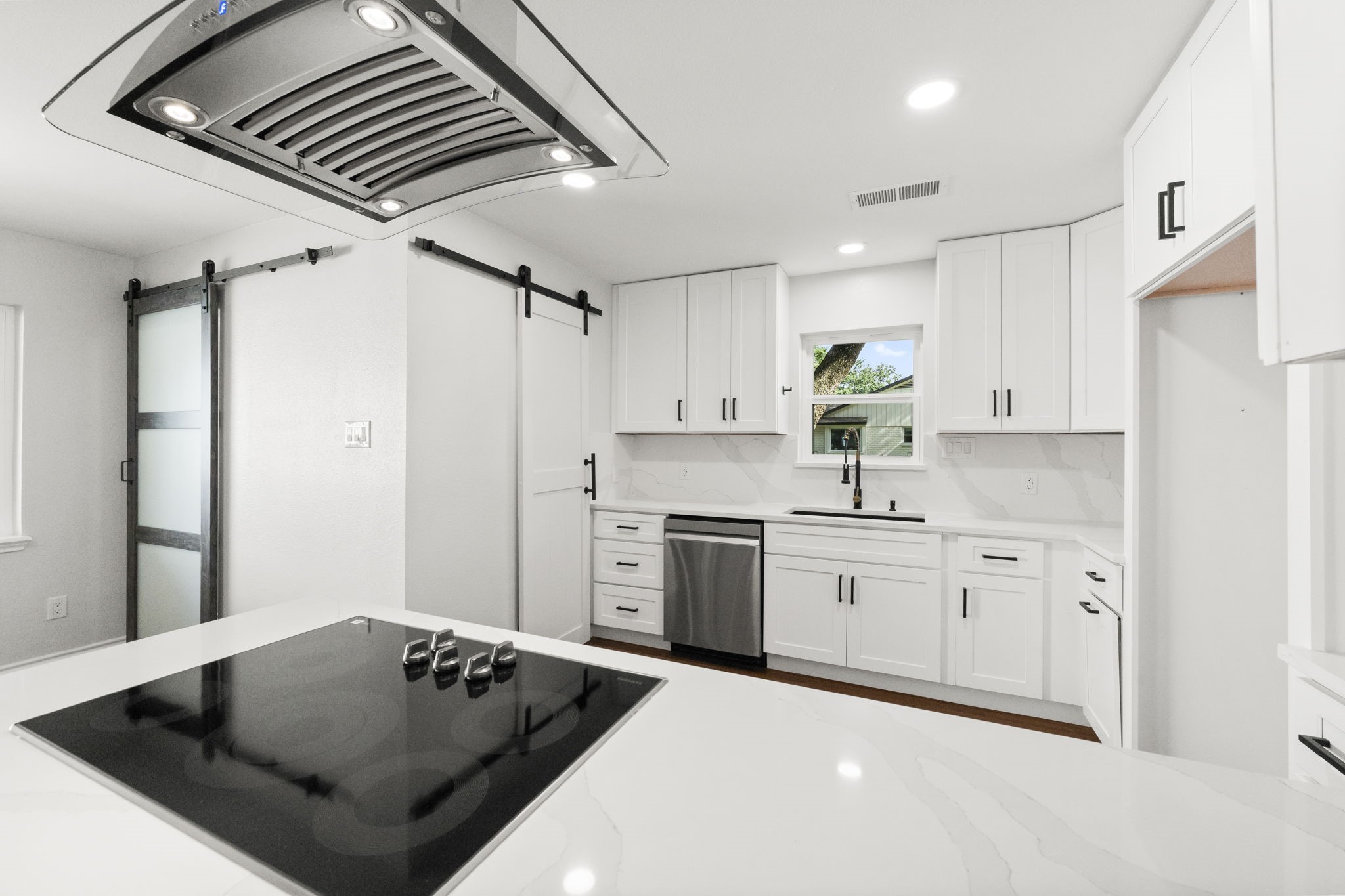 2535 Southwick Street Houston, TX 77080 - Photo 2 of 26 a kitchen with white cabinets a sink dishwasher and a stove with wooden floor