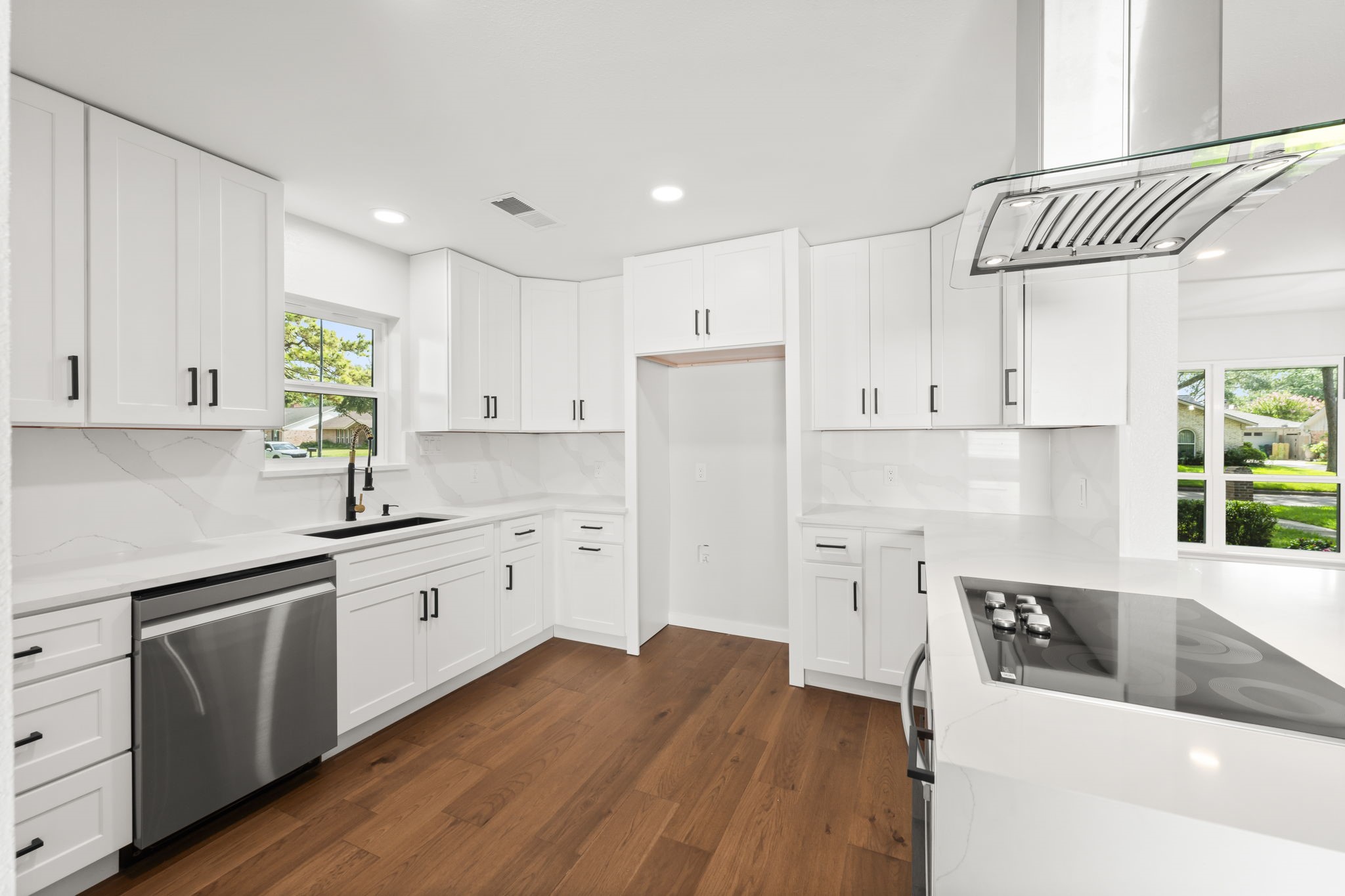 2535 Southwick Street Houston, TX 77080 - Photo 3 of 26 a kitchen with granite countertop a white refrigerator oven a sink dishwasher and white cabinets with wooden floor