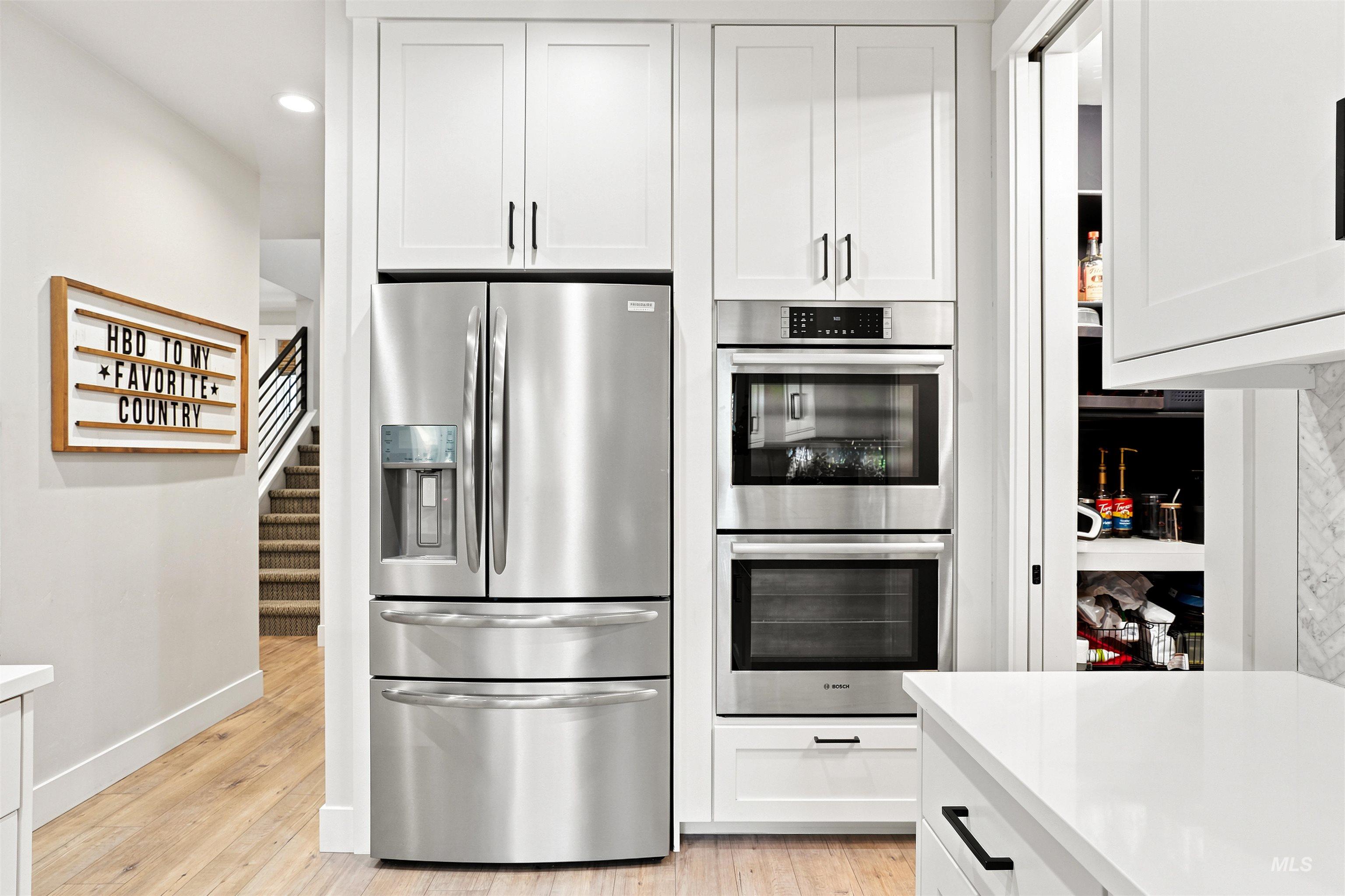 4323 West Ladle Rpds Drive Meridian, ID 83646 - Photo 12 of 49 Contemporary kitchen featuring white cabinetry, stainless steel appliances, integrated double ovens, and a built-in refrigerator