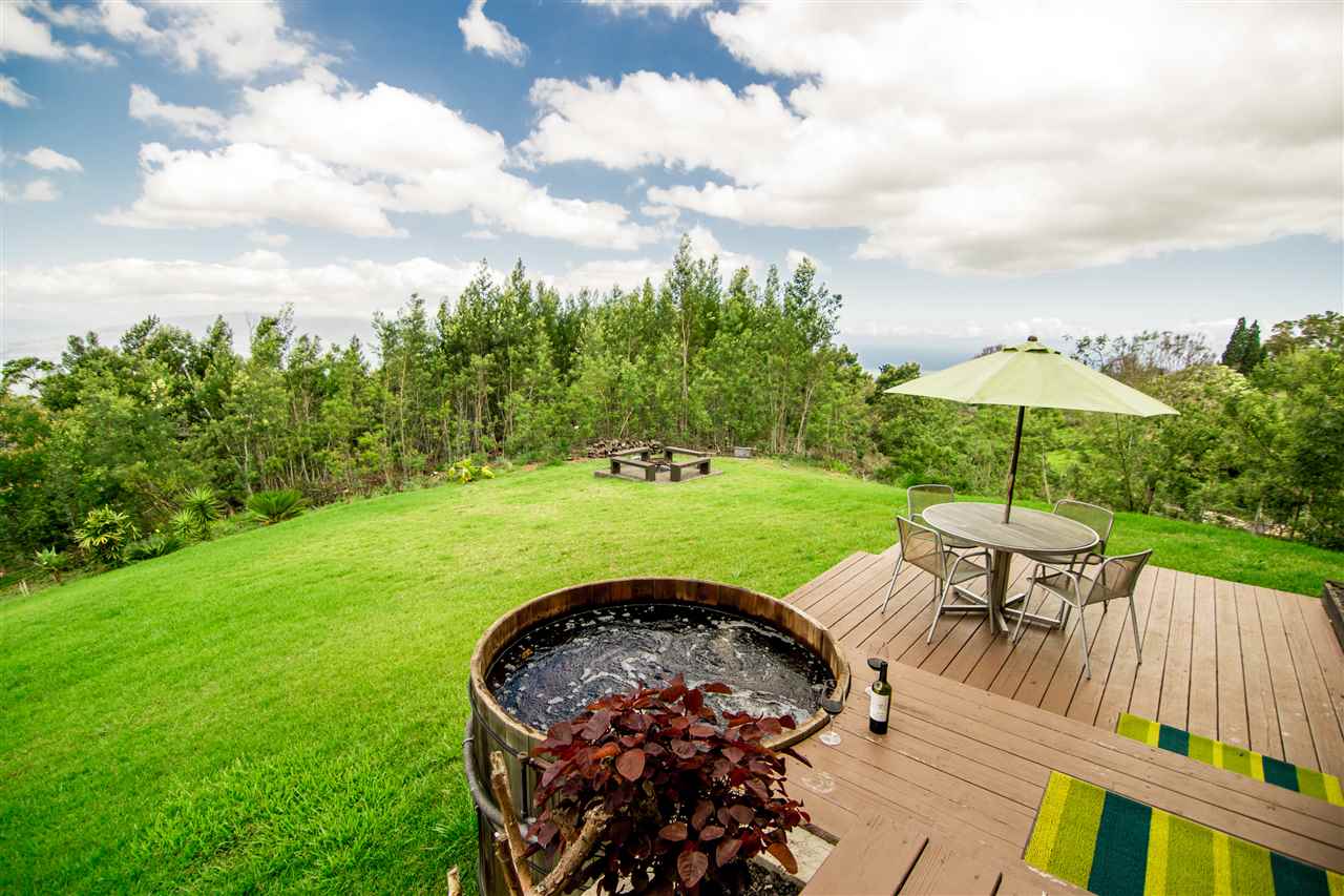 120-122 Ainakula Road Kula, HI 96790 - Photo 22 of 28 a view of a garden with a table and chairs under an umbrella