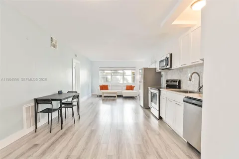 a kitchen with stainless steel appliances a stove a sink a refrigerator and wooden floor