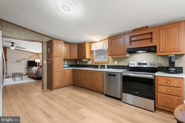 a kitchen with granite countertop a stove a sink and a refrigerator