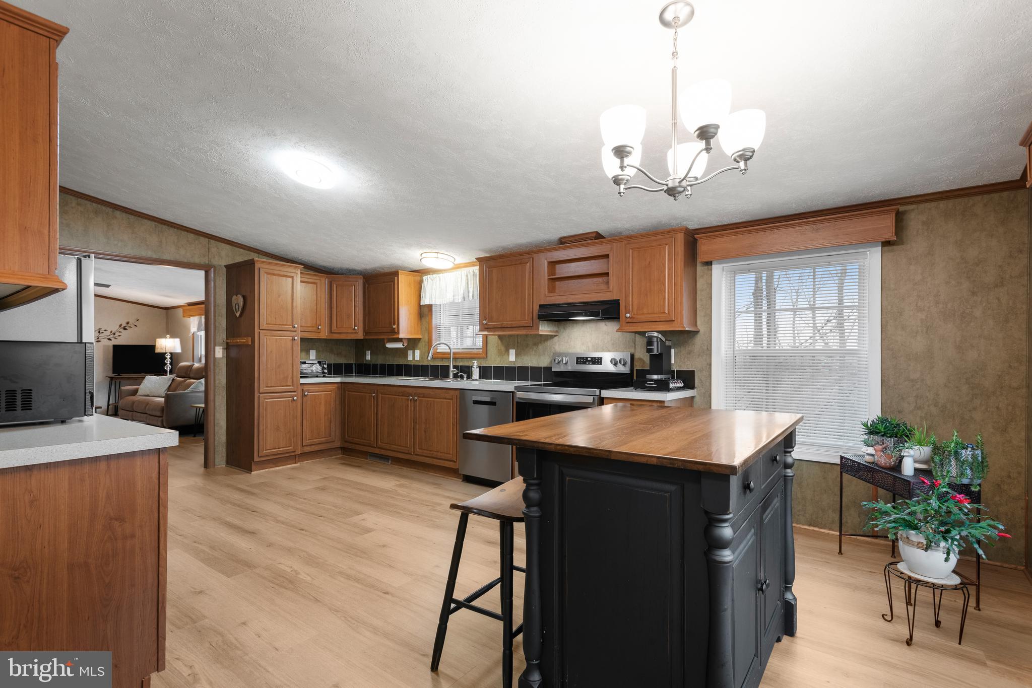 47 Janis Road Gordonville, PA 17529 - Photo 10 of 26 a kitchen with stainless steel appliances granite countertop a sink dishwasher a refrigerator a stove a dining table and chairs with wooden floor