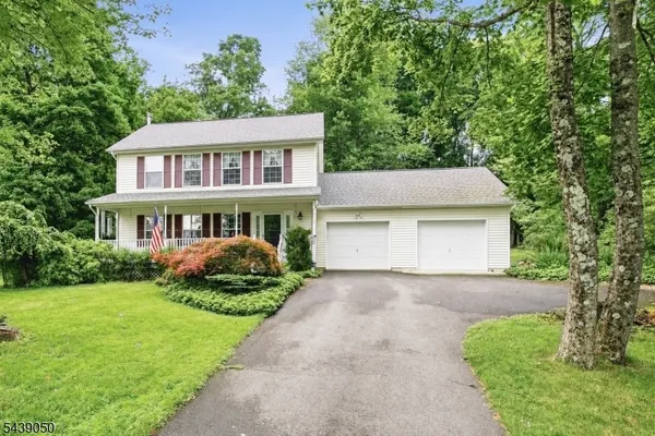 a front view of a house with a garden and plants