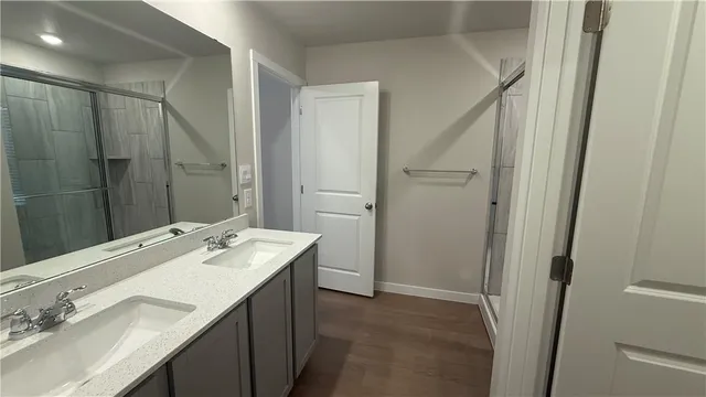 a bathroom with a sink vanity granite tub shower and a mirror