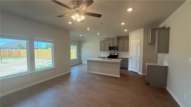 a view of kitchen with cabinets stainless steel appliances and window