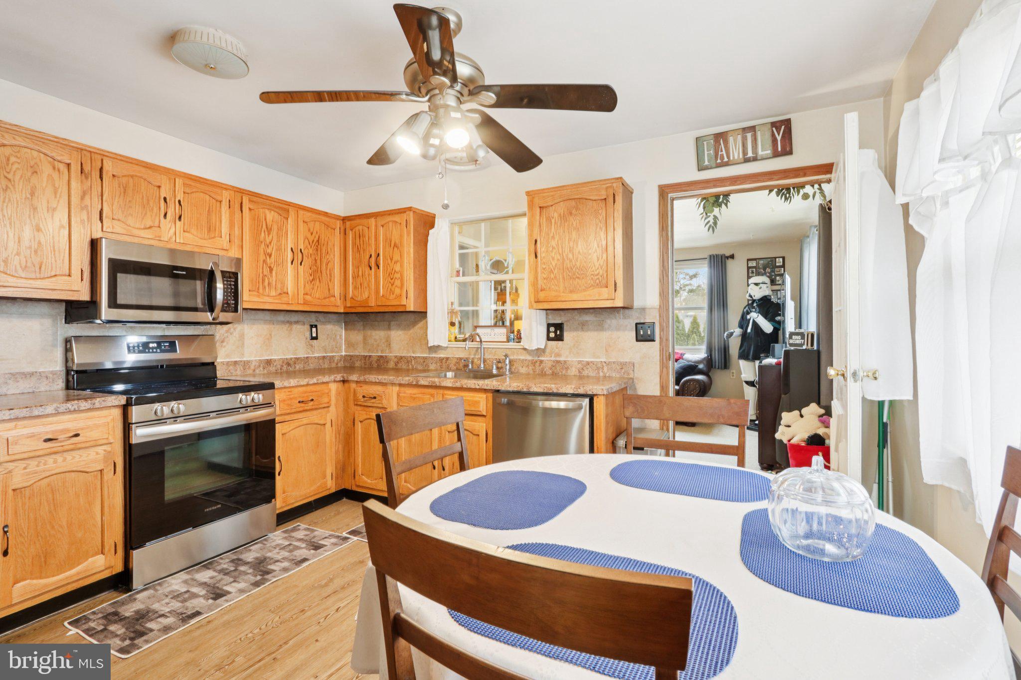 46 Gramercy Place Southampton, NJ 08088 - Photo 12 of 37 a kitchen with stainless steel appliances kitchen island granite countertop a sink dishwasher cabinets and a dining table with wooden floor