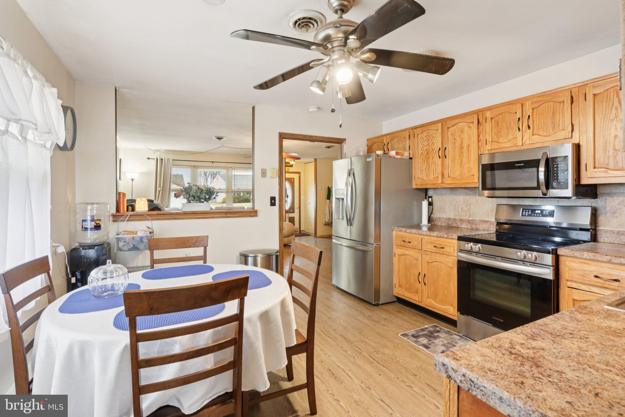 46 Gramercy Place Southampton, NJ 08088 - Photo 16 of 37 a kitchen with stainless steel appliances kitchen island granite countertop a refrigerator a stove a sink a dining table and chairs with wooden floor
