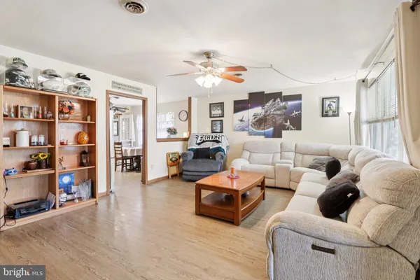 a living room with furniture and a ceiling fan