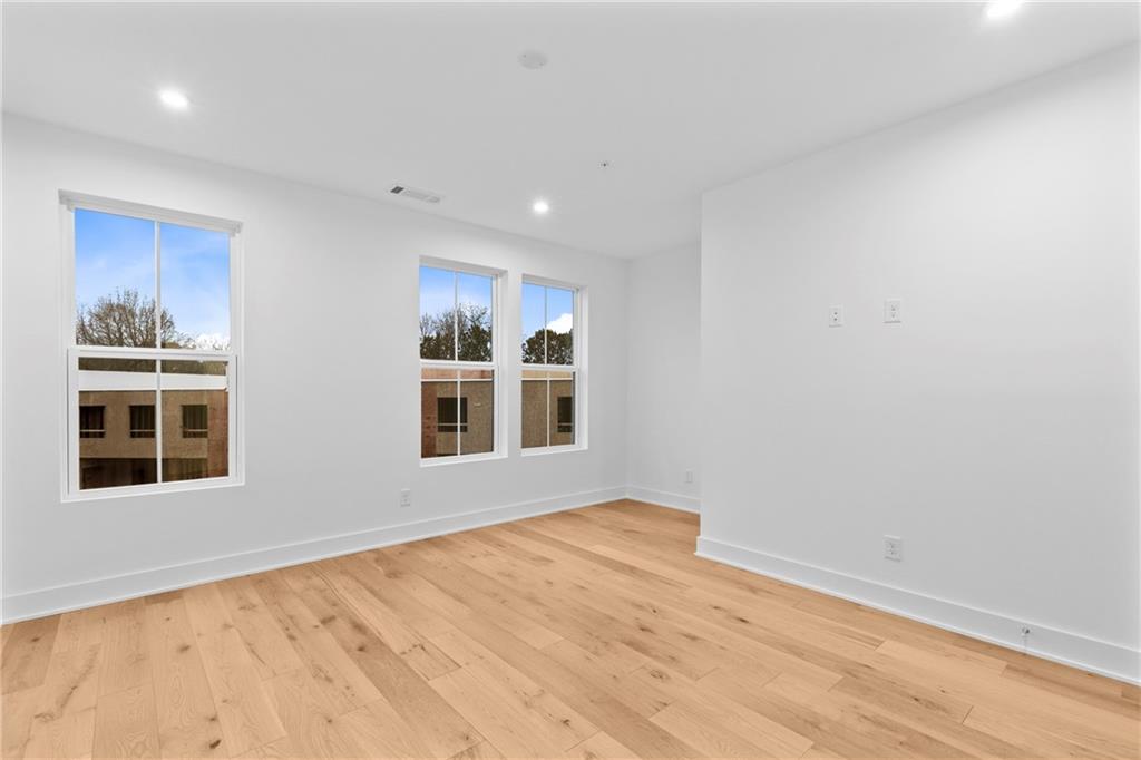 201 New Street, Unit 1204 Decatur, GA 30030 - Photo 15 of 28 a view of an empty room with a window and wooden floor