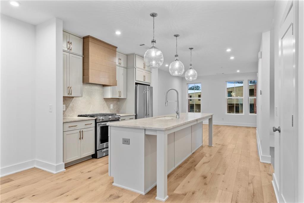 201 New Street, Unit 1204 Decatur, GA 30030 - Photo 5 of 28 a large white kitchen with stainless steel appliances granite countertop a sink a stove and a refrigerator
