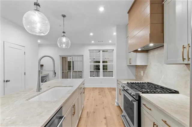 an open kitchen with sink stove and cabinets