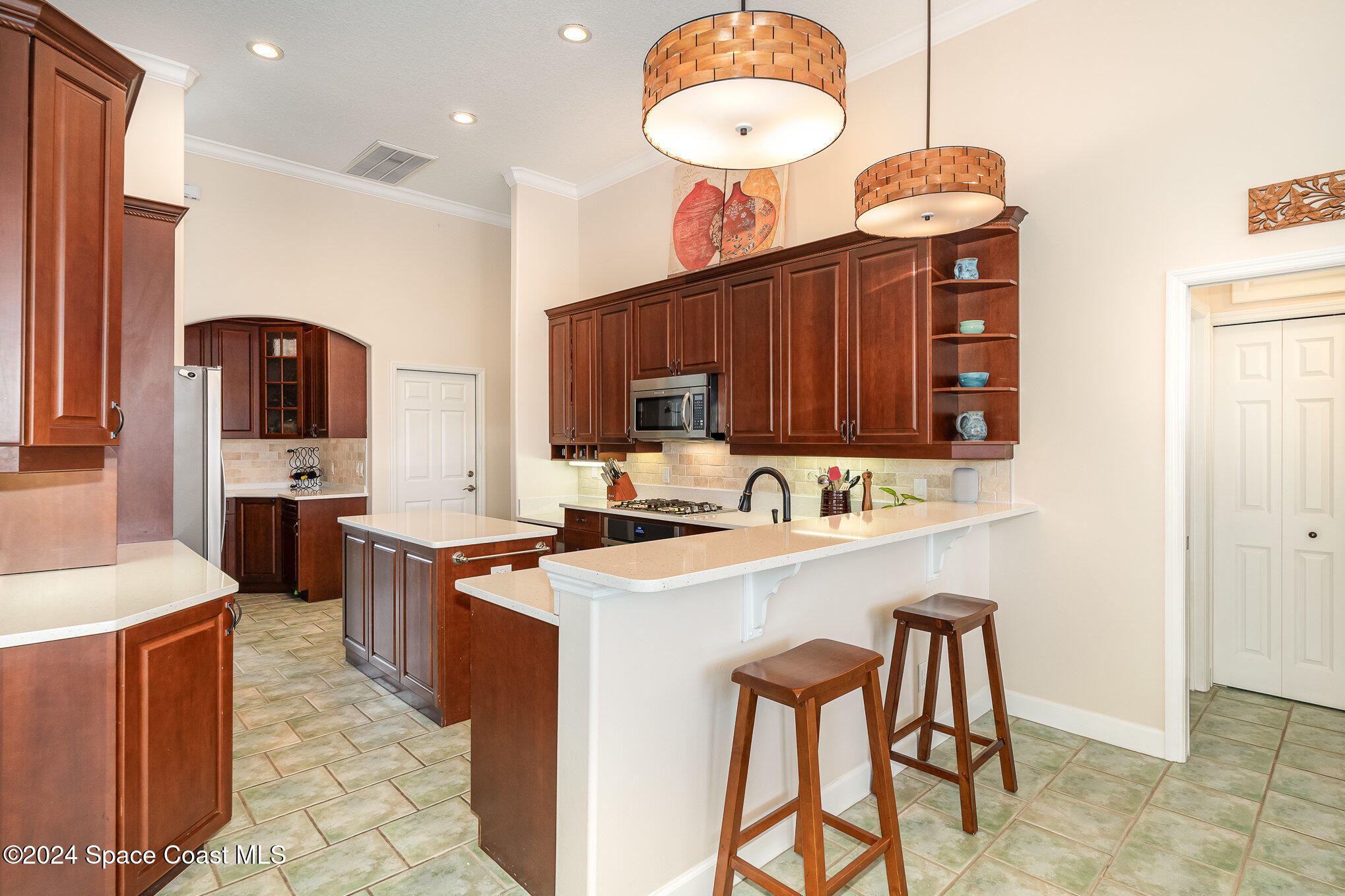 4321 Collingtree Drive Rockledge, FL 32955 - Photo 14 of 70 a kitchen with stainless steel appliances a sink a stove a refrigerator cabinets and chairs