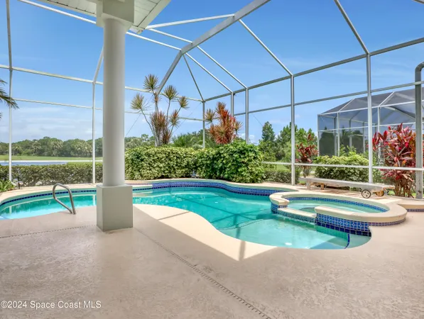 a kitchen with stainless steel appliances a sink a stove a refrigerator cabinets and chairs