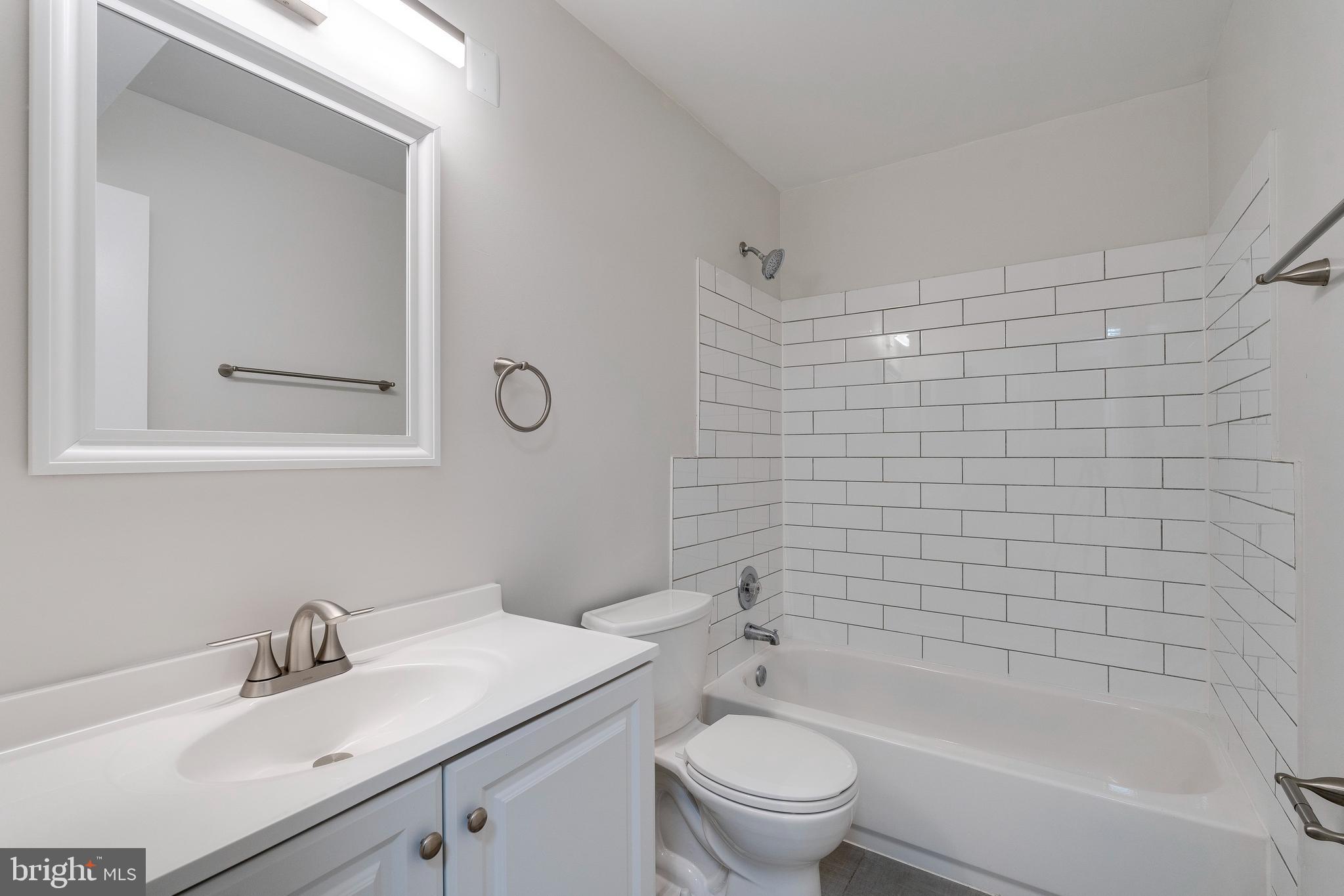 6 Normandy Square Court, Unit 2CB Silver Spring, MD 20906 - Photo 13 of 28 a bathroom with a bathtub shower sink vanity mirror and toilet