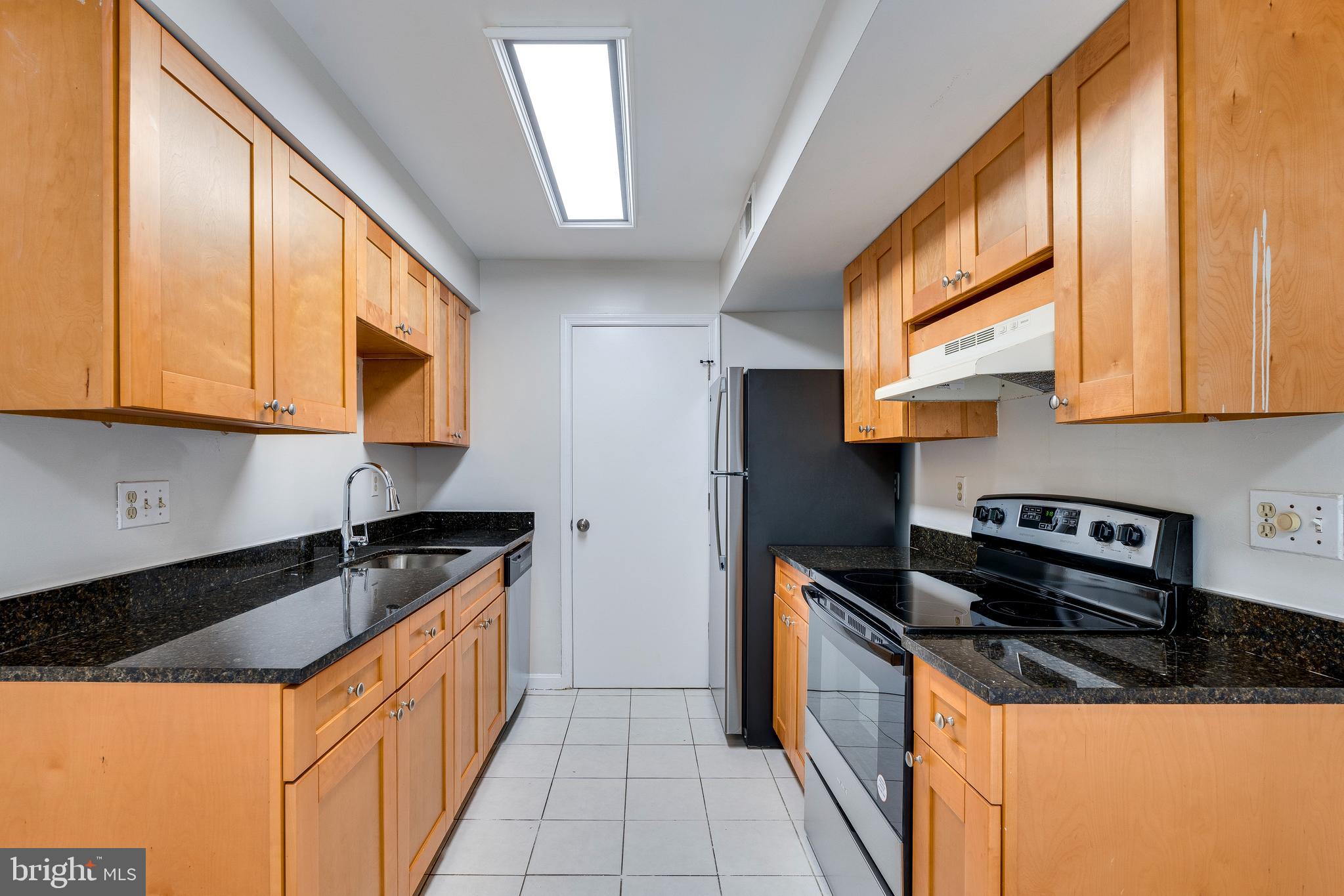 6 Normandy Square Court, Unit 2CB Silver Spring, MD 20906 - Photo 7 of 28 a kitchen with granite countertop a sink a stove and cabinets