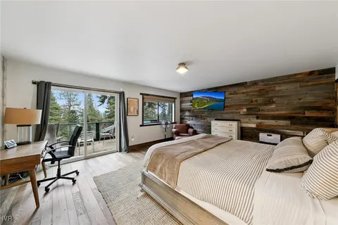 a bedroom with a bed a table and large window