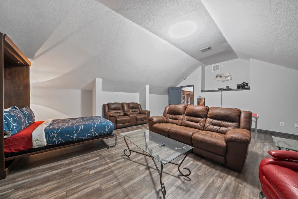 209 Lakeview Circle Spring Branch, TX 78070 - Photo 27 of 40 Home theater featuring a textured ceiling, visible vents, vaulted ceiling, and wood finished floors
