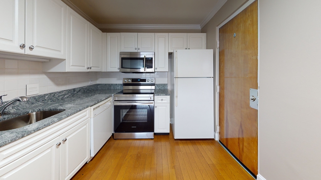 326 Broadway, Unit 21 Somerville, MA 02145 - Photo 1 of 8 a kitchen with stainless steel appliances a refrigerator stove and sink