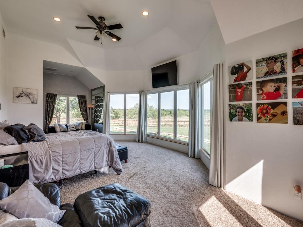 2250 Morrow Road Valley View, TX 76272 - Photo 16 of 35 a spacious bedroom with a bed a couch and a large window