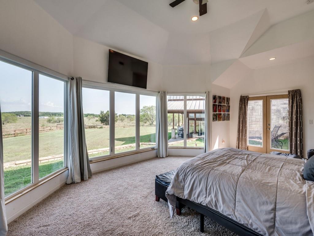 2250 Morrow Road Valley View, TX 76272 - Photo 17 of 35 a bed sitting in a spacious bedroom next to a large window with a flat screen tv