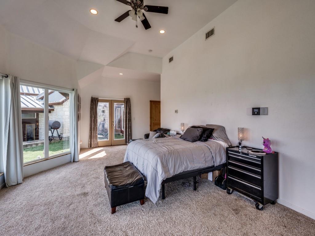 2250 Morrow Road Valley View, TX 76272 - Photo 18 of 35 a spacious bedroom with a bed and a chandelier